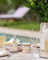 Durance Raumspray, Duftkerze und Diffusor Pêche de Vigne Weinbergpfirsich auf Gartentisch vor Pool