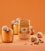 A L'Olivier Walnussöl in Dose mit ganzen Walnüssen auf orangefarbener Fläche
