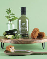 A L'Olivier Fruchtessig mit Zucchini und Minze neben frischer Zucchini und Minzblättern
