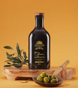 A L'Olivier Oliviers Centenaires Olivenöl mit grünen Oliven und Olivenzweigen auf Holzbrett