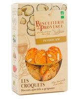 Produktbild der Biscuiterie de Provence „Les Croquets – Picodon AOP“: Verpackung mit Ziegenkäse-Illustrationen und Sichtfenster, gefüllt mit knusprigen Aperitif-Brotscheiben mit Mandeln