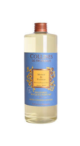 Collines de Provence Duftdiffuser-Nachfüllung Monoi und Passionsfrucht in transparenter Flasche mit hellgelber Flüssigkeit auf hellem Hintergrund.