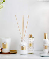 Collines de Provence Duftkollektion mit Duftdiffuser Neroli, Duftdiffuser-Nachfüllung Neroli, Raumspray Baumwolle und Duftkerze Baumwolle auf weißem Regal vor hellem Hintergrund.