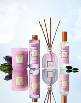 Collines de Provence Duftkollektion Patchouli & Tonkabohne mit Duftkerze, Duftdiffuser, Raumspray und Nachfüllung auf spiegelnder Oberfläche