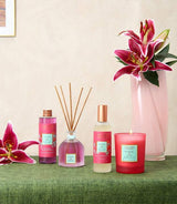 Collines de Provence Raumduftkollektion Tigerlilie & Lotus mit Duftdiffuser, Raumspray, Duftöl und Duftkerze neben blühenden Lilien