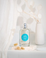 Durance Eau de Toilette Baies Exquises als elegante Lifestyleaufnahme mit Flakon auf Steinplatte, dekoriert mit Trockenblumen und hellem, minimalistischem Hintergrund