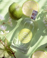Durance Eau de Toilette Bergamote Radieuse 100 ml Flakon mit Limetten und Blüten dekorativ inszeniert