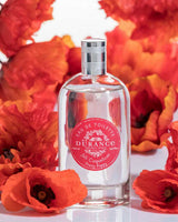 Durance Eau de Toilette Joli Coquelicot 100 ml, dekorativ inszeniert mit leuchtend roten Mohnblüten für eine florale und ausdrucksstarke Produktdarstellung