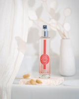Durance Körperspray Pretty Poppy in transparenter Flasche auf Stein dekoriert in heller, natürlicher Umgebung
