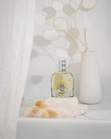 Durance Eau de Parfum Sensuel Monoï 50 ml als Flakon in minimalistischer, heller Inszenierung mit Naturstein, Trockenblumen und sanften Schatten – vermittelt die warme, exotische Duftnote von Monoï in eleganter Atmosphäre