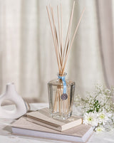 Durance Monoï-Blüte Diffuser auf Büchern neben weißen Blumen in hellem Wohnambiente