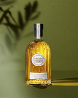 Château d'Estoublon Olivenöl Vallée des Baux de Provence 500ml in geriffelter Glasflasche vor grünem Hintergrund mit Schatten