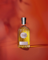 Château Estoublon Salonenque Olivenöl in dekorativer Glasflasche vor rotem Hintergrund