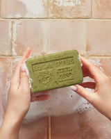 La Maison du Savon de Marseille Eukalyptus-Seife mit Sheabutter, grün in Händen mit Schaum.