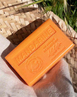 La Maison du Savon de Marseille Seife Mandarine mit Bio-Sheabutter dekorativ in einem natürlichen Flechtkorb mit Leinenstoff arrangiert.