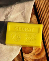 La Maison du Savon de Marseille Seife Zedratzitrone mit Bio-Sheabutter auf einem Holztisch.