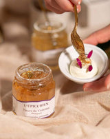 Serviervorschlag mit L'Épicurien Veilchenblüten-Gelee aus der Provence: Ein geöffnetes Glas steht neben einer Schale mit Dessert, das mit Veilchenblüten-Gelee und essbaren Blüten verfeinert wird.
