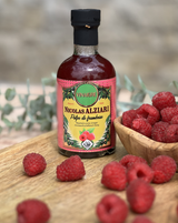 Nicolas Alziari Himbeer Essig in Glasflasche mit frischen Himbeeren auf Holztisch
