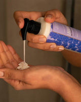 Nahaufnahme der Anwendung der Panier des Sens Körperlotion Lavendel aus der Provence 250ml. Eine Person dosiert die pflegende Lotion mit dem Pumpspender in die Handfläche.