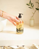Panier des Sens Flüssigseife Olive im Badezimmer mit Hand auf Waschbecken