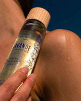Panier des Sens Massage- und Körperöl Lavendel aus der Provence 100ml bei der Anwendung auf der Haut mit pflegendem Öl und natürlicher Wellness-Atmosphäre unter blauem Himmel