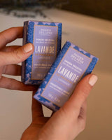 Panier des Sens Pflanzenseife Lavendel in den Händen gehalten mit dekorativer violetter Verpackung