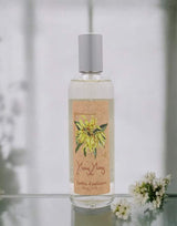 Provence et Nature Raumduftspray Ylang-Ylang mit Blüten dekorativ auf einer Glasfläche