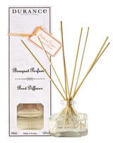 Durance Diffuser Weinbergpfirsich Pêche de Vigne: Glasflakon mit Rattanstäbchen neben weißer Originalverpackung