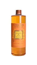 Collines de Provence Duftdiffuser-Nachfüllung Mandarine und Yuzu in transparenter Flasche mit orangefarbener Flüssigkeit auf hellem Hintergrund.