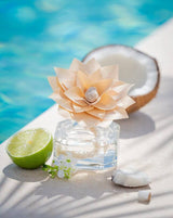 Diffuser mit Holzduftblume, Duftnote Kokoswasser von Durance neben einer Limette vor einem Pool