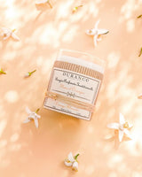Durance Duftkerze Orange Blossom, 180g dekoriert mit weißen Blüten auf hellem Hintergrund