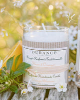 Durance Duftkerze Fleur d'Oranger, 180g im frischen Ambiente mit Blüten und grünen Zweigen