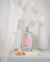 Durance Eau de Toilette Délicat Nymphéa 100 ml Flakon dekorativ auf Stein mit natürlichem Hintergrund inszeniert
