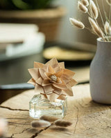 Durance Holzduftblume 100ml mit dekorativer Holzblüte und elegantem Glasflakon auf rustikalem Holztisch mit stilvoller Wohnraumdekoration und Trockenblumen im Hintergrund