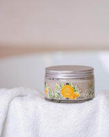 Durance Körperpeeling Orangenblüte im Glastiegel auf Handtuch im Badezimmer platziert