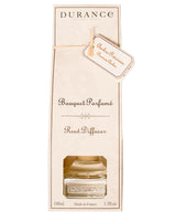Durance Raumduft Diffuser Edelamber 100ml in cremefarbener Verpackung mit orangefarbenem Duftanhänger und Sichtfenster auf die Glasflasche