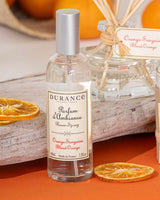 Durance Raumspray Blutorange mit getrockneten Orangenscheiben und Duftdiffuser auf dekorativem Untergrund