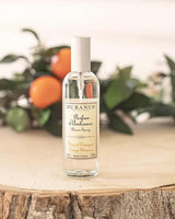 Durance Raumspray Orange Blossom auf Holzoberfläche mit Orangenzweigen im Hintergrund