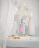 Durance Eau de Toilette Rose Pétale als stilvolle Lifestyleaufnahme mit Flakon auf Steinplatte, dekoriert mit Trockenblumen und hellem Interieur im Hintergrund