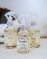 Durance Wäschespray Monoi-Blüte mit mehreren Flakons im Hintergrund