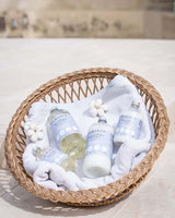 Durance Wäschepflege Set mit Weichspüler und Waschprodukten im Korb mit Handtuch und Baumwollblüten dekoriert
