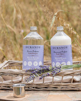 Durance Waschmittel und Weichspüler Lavendel in Glasflaschen im Korb mit frischen Lavendelblüten im Freien