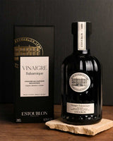 Château d'Estoublon Balsamicoessig Balsamique 200ml in dunkler Glasflasche mit Verpackung auf Tisch in stimmungsvoller Umgebung