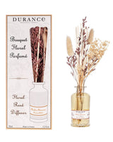 Durance Floral Reed Diffuser Ambre Précieux Duftdiffuser mit Trockenblumen im Glasflakon neben Verpackung