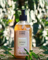 Marius Fabre Flüssigseife Verveine in Pumpflasche mit grünen Pflanzen im Hintergrund