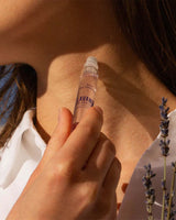 Panier des Sens Eau de Toilette Lavendel aus der Provence 10ml bei der Anwendung am Hals mit Lavendelzweigen in natürlicher provenzalischer Atmosphäre