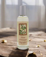 Provence et Nature Raumduftspray Orangenblüte auf rustikalem Holztisch mit Blütenblättern